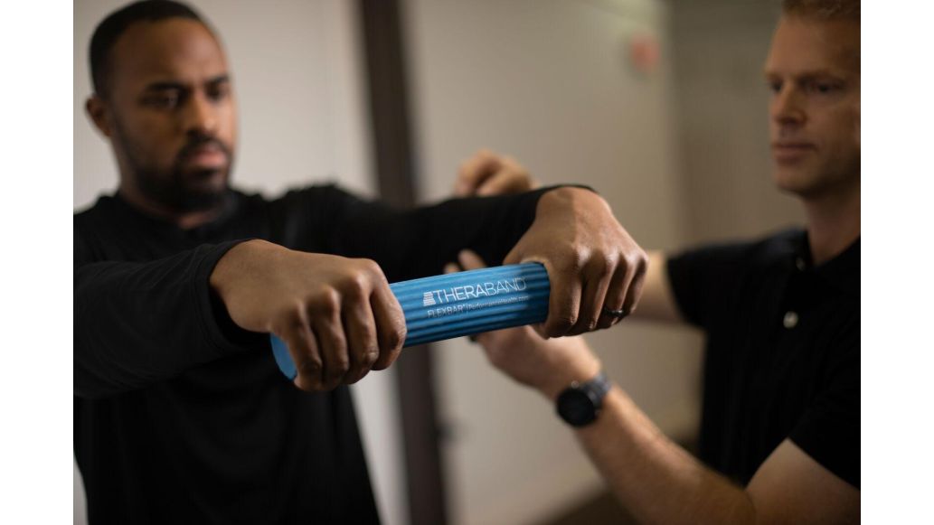clinician using THERABAND flexbar on patient