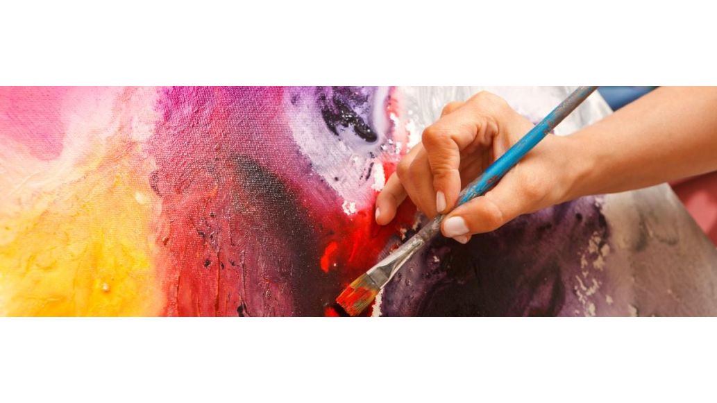 person painting with a paintbrush in hand